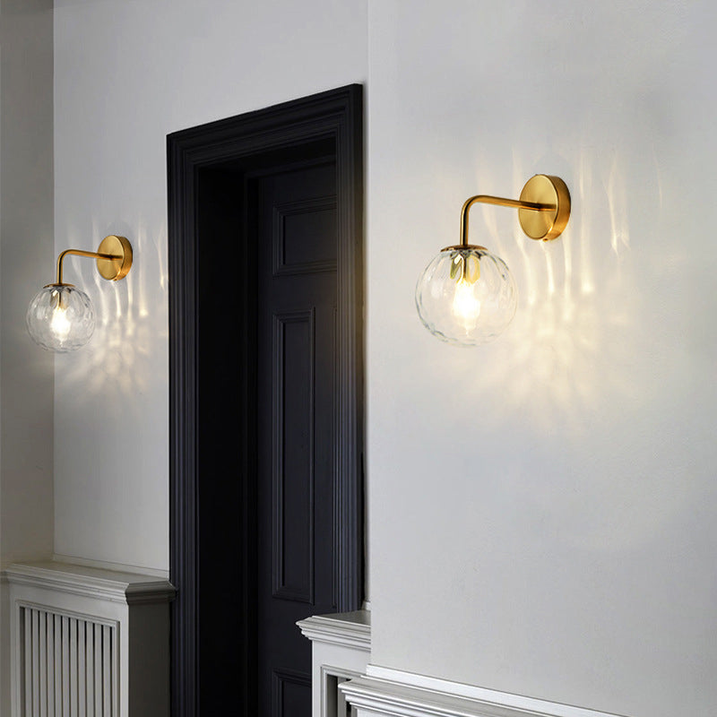 Wandlamp met glazen bolkap en gestructureerde finish voor sfeervolle wandverlichting gouden armatuur | Sulvida